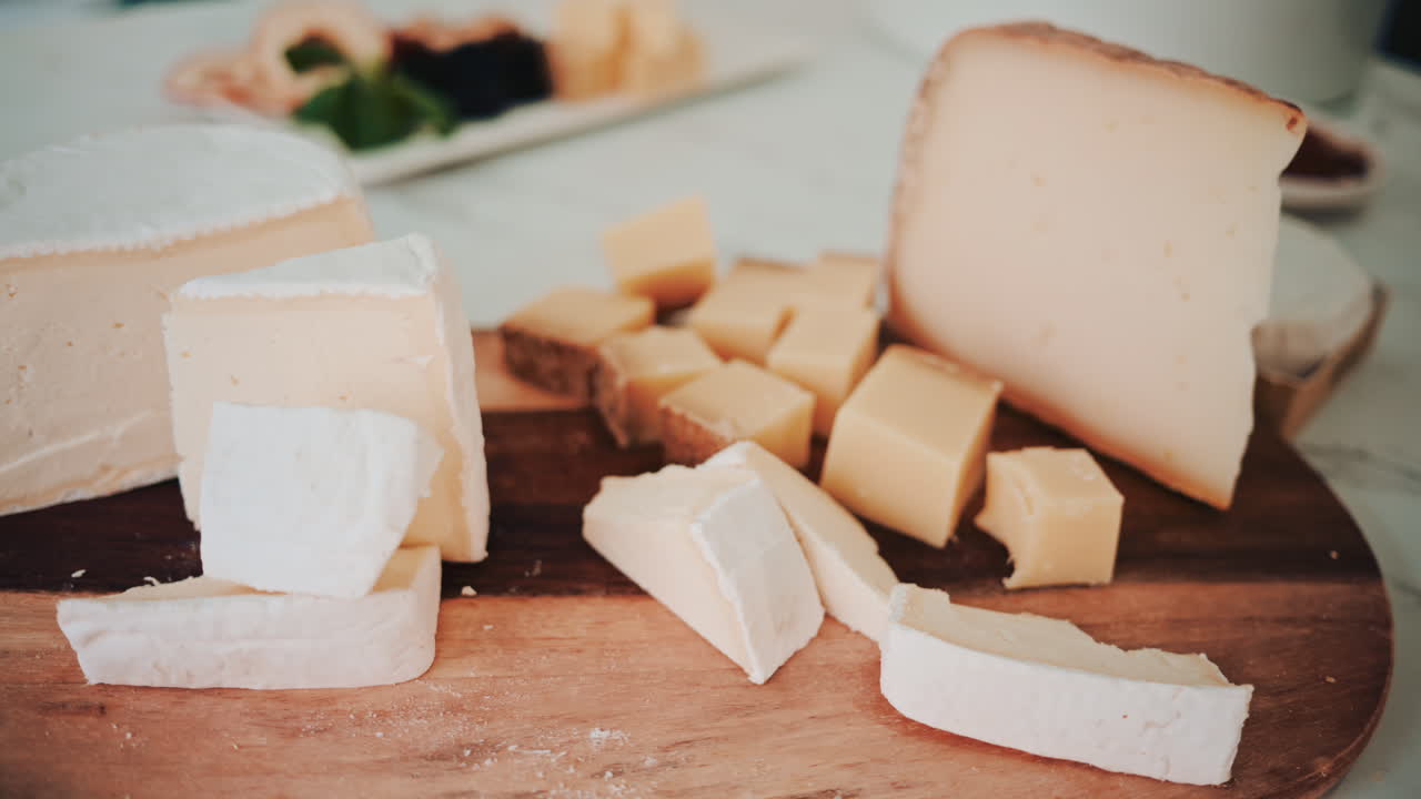Selection of assorted cheeses arranged on a wooden board, captured in natural light