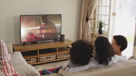 composite of happy family sitting at home together watching sports event on tv