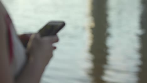 using cell phone by the river in slow motion