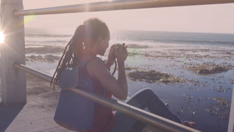 animation of light spots over biracial woman taking photo with camera on promenade