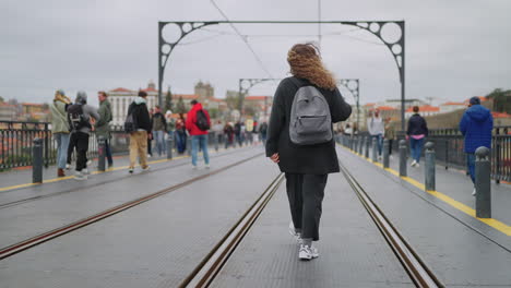 mujer caminando por un puente en una ciudad