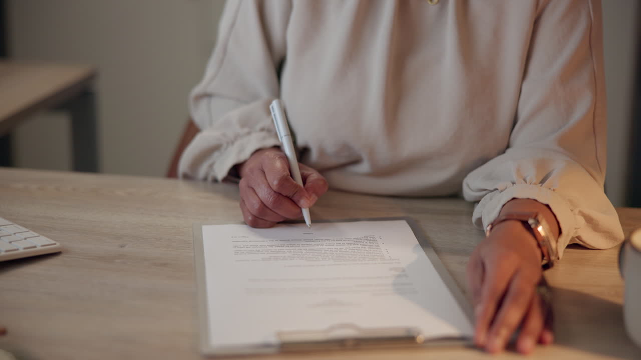 Woman signing a document at her desk