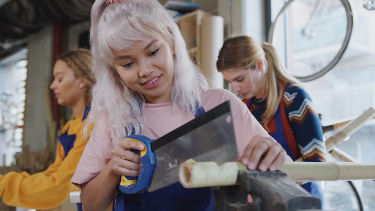 команда женщин-стажеров в мастерской учится собирать ручной велосипедный каркас вместе