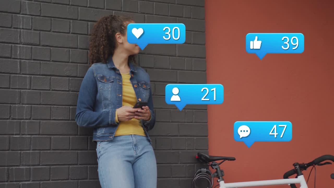 Animation of notification labels, smiling biracial woman standing beside bicycle and using cellphone