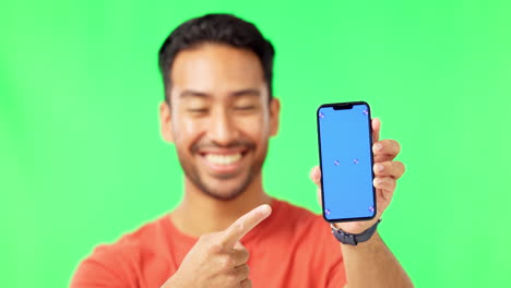 hombre feliz, teléfono y apuntando a la maqueta en verde