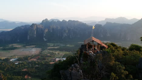 Little-bamboo-hut-on-top-of-a-mountain-during-sunset-in-Laos-with-amazing-view-on-green-and-sandy-landscape