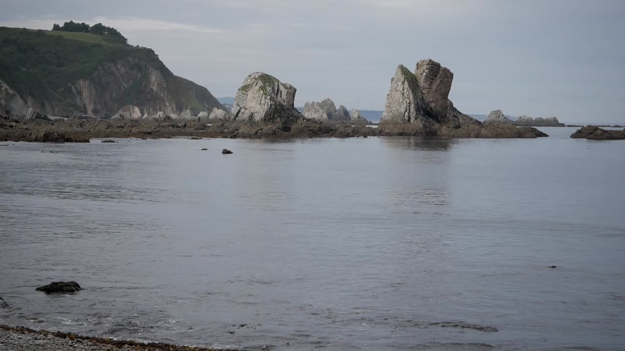 Rocky coast at low tide, Silence Beach, Asturias, with calm sea and soft daylight