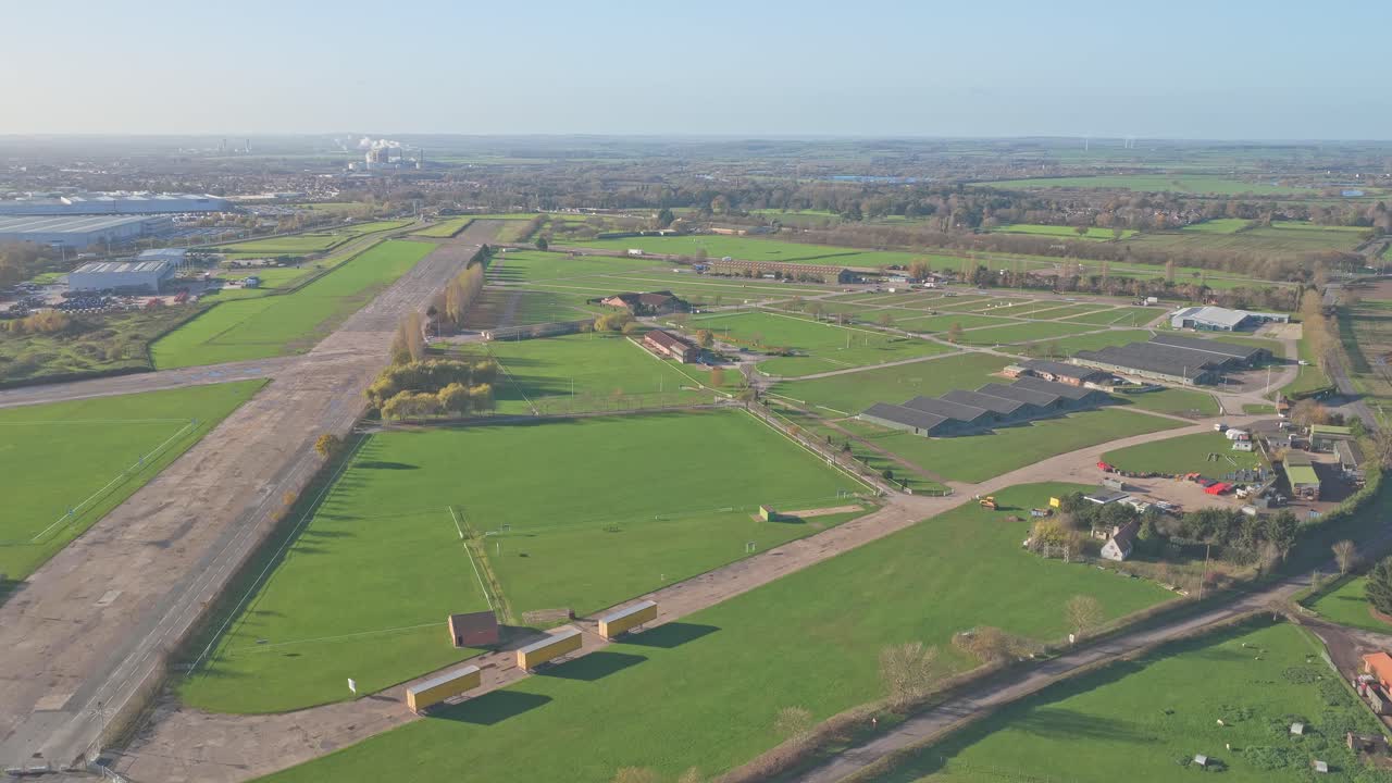 Aerial over the former RAF Winthorpe runway at Newark Air Museum in Nottinghamshire, revealing taxiways, service buildings, rural roads, and the flat agricultural landscape of the East Midlands