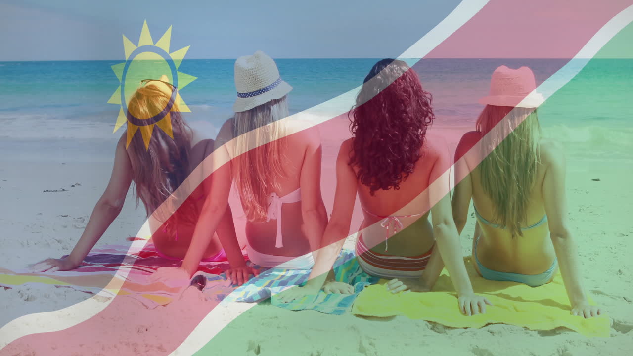 Sitting on beach, four women with Namibia flag overlaying animation scene