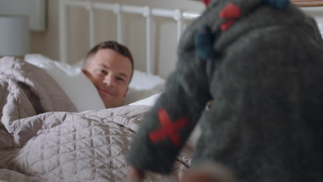 happy children jumping on bed waking up mother and father enjoying playful morning with kids