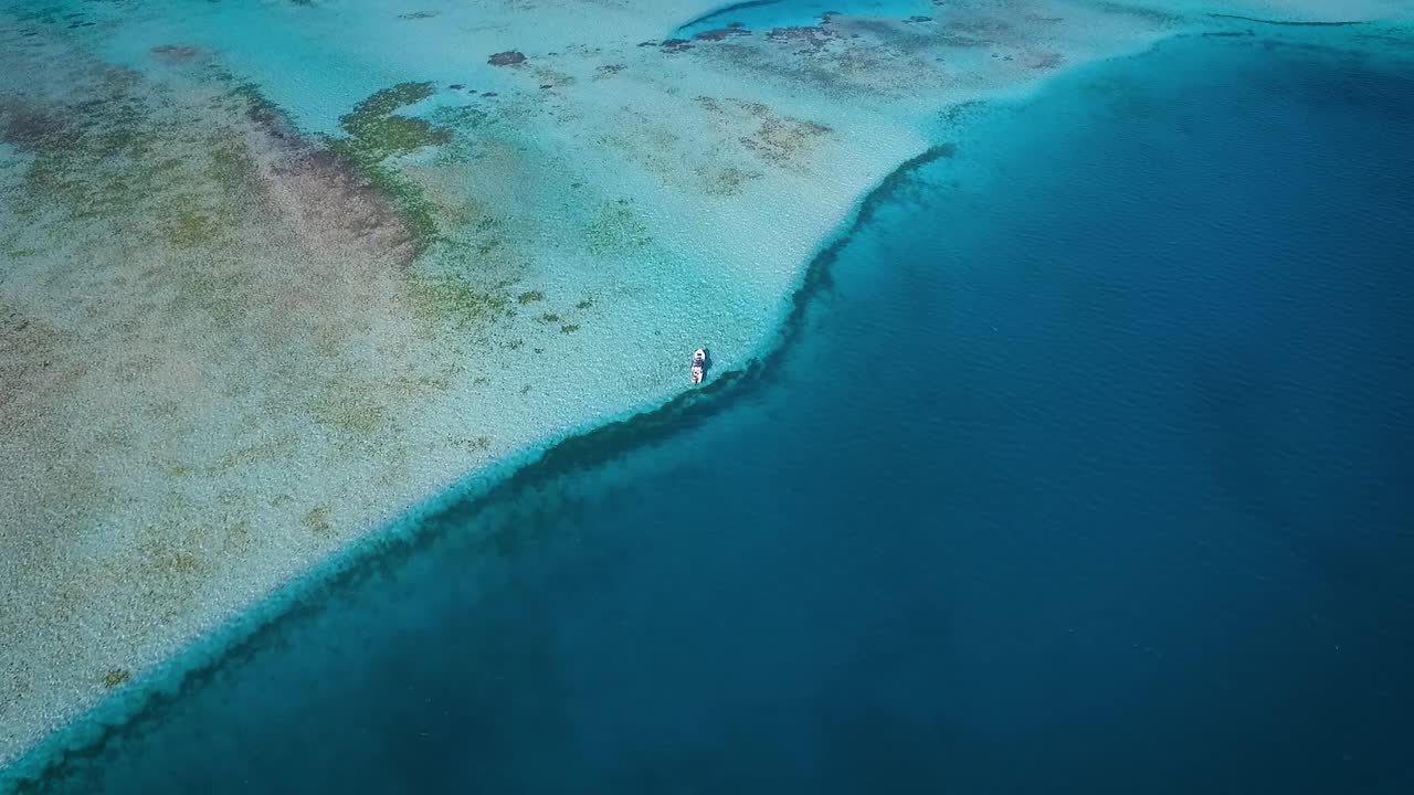 desde la vista superior de un pequeño barco de pesca, flotando en el mar caribe azul, en los roques venezuela