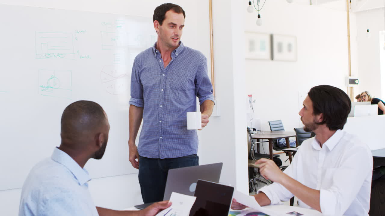 tres jóvenes discutiendo negocios en una reunión de oficina