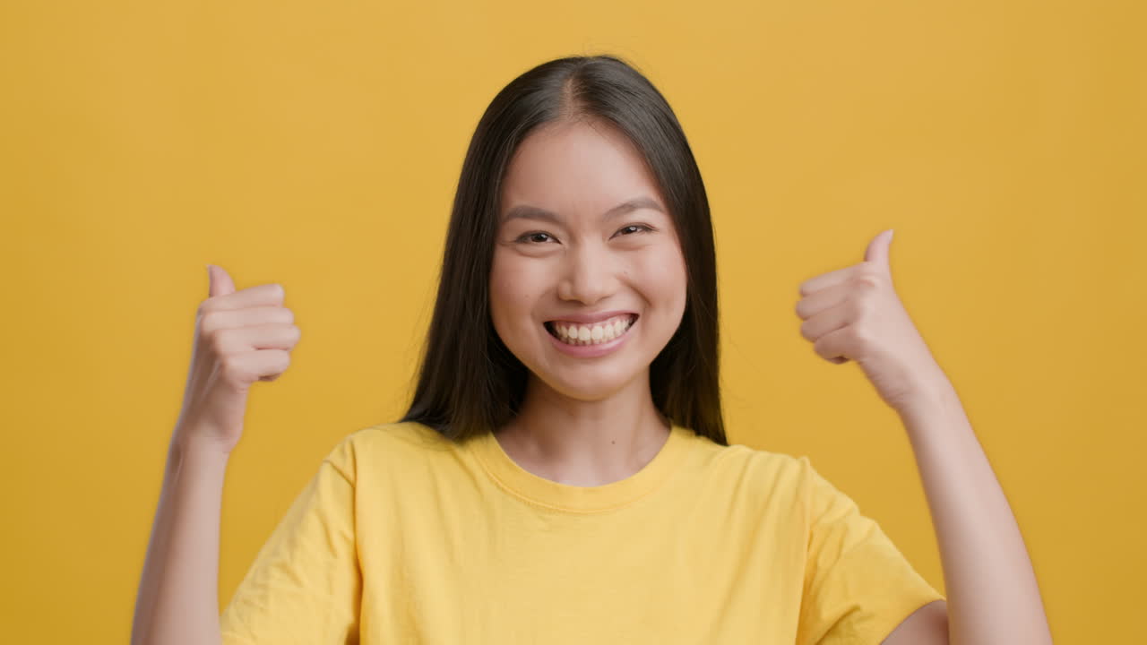 Young Asian Woman Giving Thumbs Up and Smiling