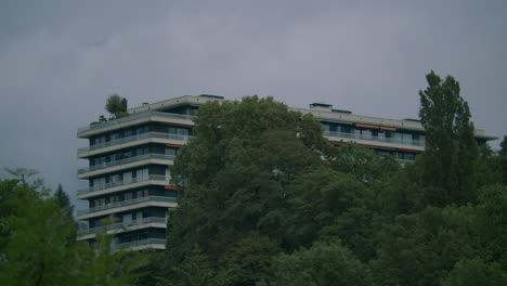 apartment building amidst lush greenery on an overcast day