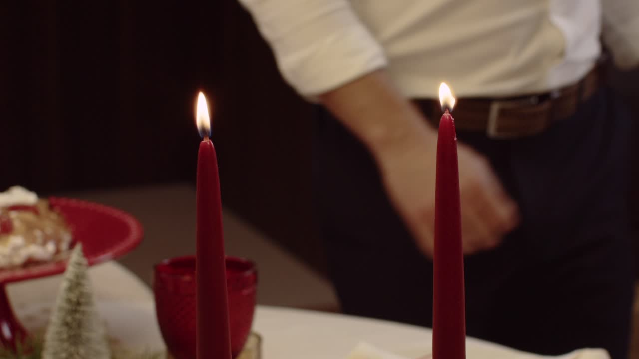 close up of lit red taper candles creating warm christmas ambiance