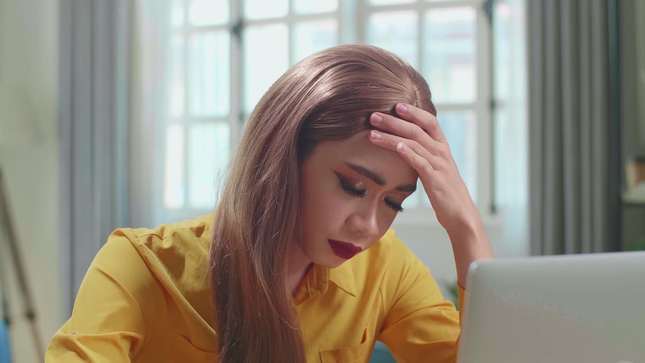 Stressed Asian Young Transgender Woman Working With Laptop Computer In Living Room