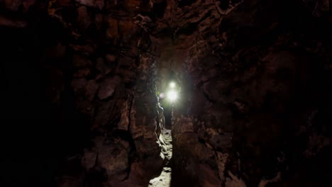 excursionista masculino explorando una cueva oscura 4k