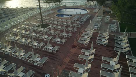 cinematic drone clip leaning over a swimming pool and lounge chairs in a luxurious hotel resort in mallorca, spain