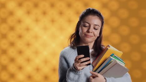 Mujer-Sonriente-Leyendo-Mensajes-En-Un-Teléfono-Inteligente-Mientras-Sostiene-Una-Pila-De-Libros