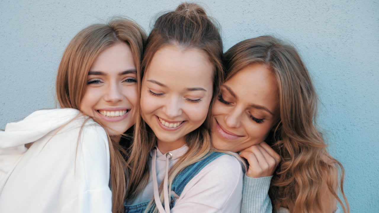 세 명의 친구들이 포옹하고 있습니다.