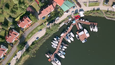 Drone-Flyover-Top-Shot-Vista-Aérea-De-Pájaro-De-Pequeños-Barcos,-Barcos-Y-Yates-Privados-En-El-Nuevo-Puerto-De-Mikolajki-En-Polonia-En-El-Lago-Mikolajskie---El-Destino-Turístico-Más-Famoso