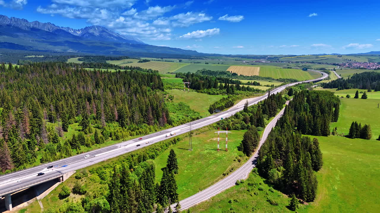 Modern highways crossing the beautiful nature landscape. Aerial perspective on the stunning valley with forest and spectacular mountains at backdrop. Slovakia.