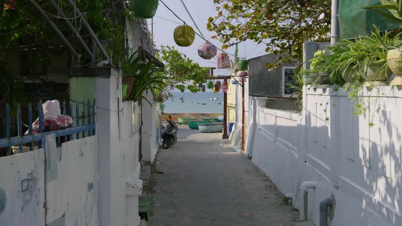 Beautiful cinematic view in narrow alley in Vietnamese fishing village with ocean