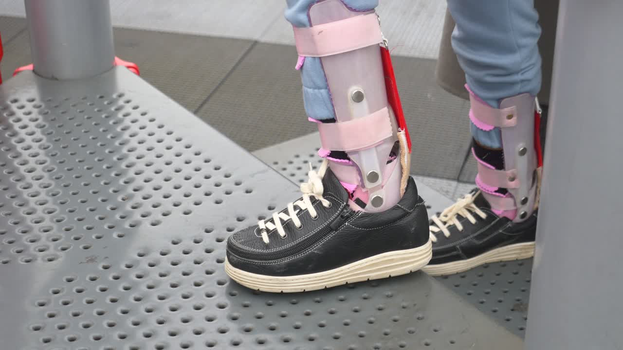 발목 브레이스 를 착용 한 사람 이 계단 을 올라가고 있다