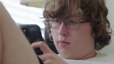 tight shot of young man on cell phone, texting