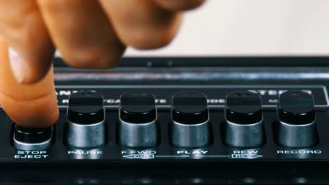 pushing play button on a vintage tape recorder