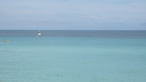 Wunderschönes-Blaues-Meer-Mit-Leuten,-Die-Windsurfen-Und-Kajak-Fahren