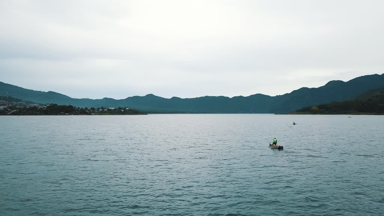 과테말라 아티틀란 호수에서 보트를 타고 노를 젓는 현지 남자 - 드론 공중 전망, 회전 샷