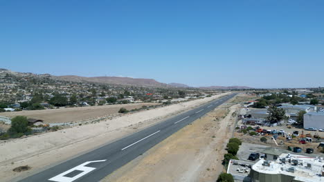 aerial drone shot showcasing runway at a small general aviation airport and surrounding area