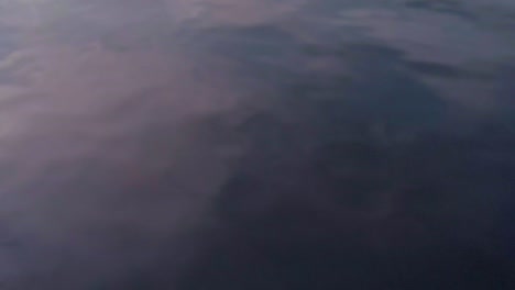 fondo abstracto de la superficie del agua oscura con reflejo del cielo