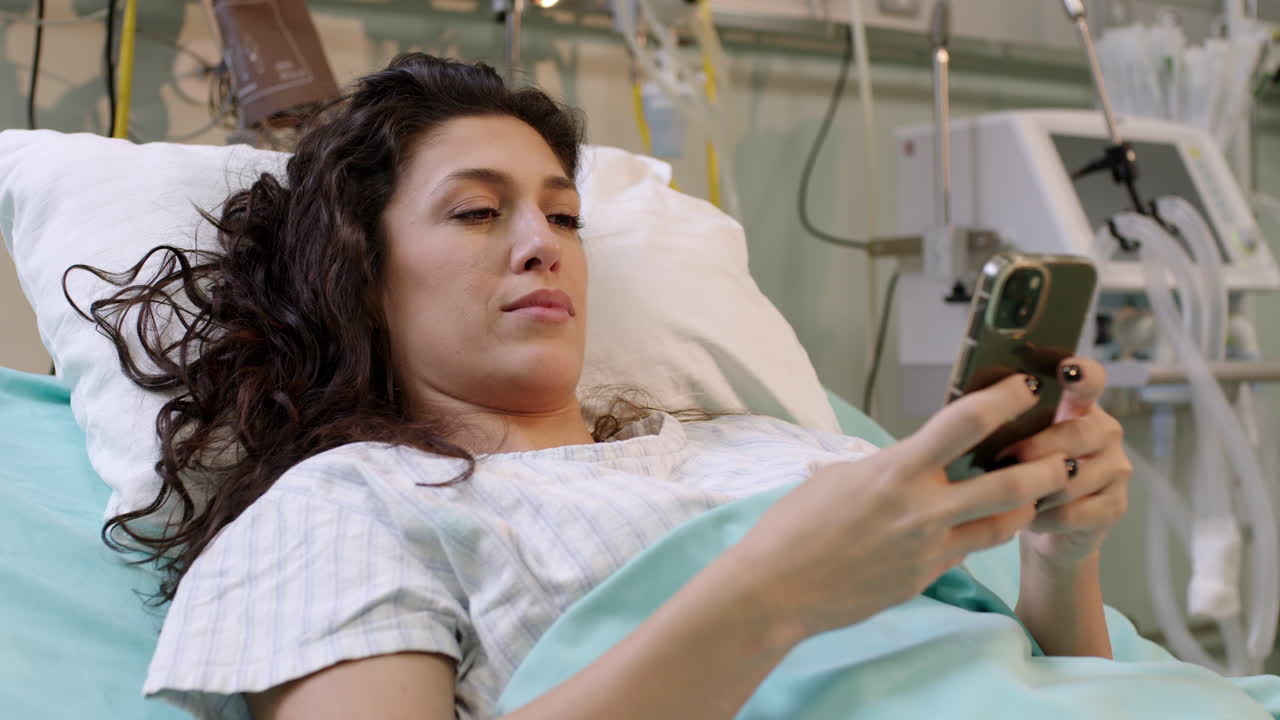 Woman Using Cell Phone in Hospital Bed