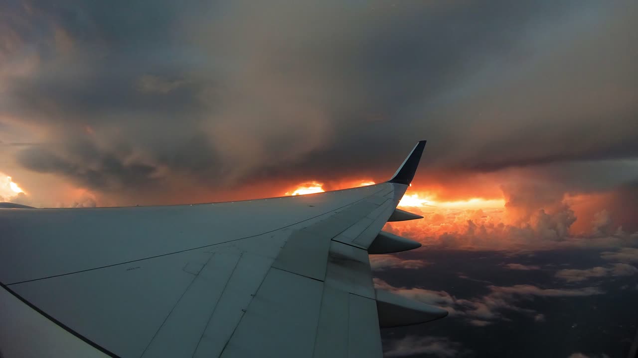 ala de avión con nubes espesas y puesta de sol