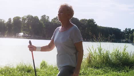 senior woman practicing nordic walking  in the park