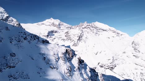 vista aérea del paisaje montañoso cubierto de nieve con bosques en un soleado día de invierno en alp grum, suiza