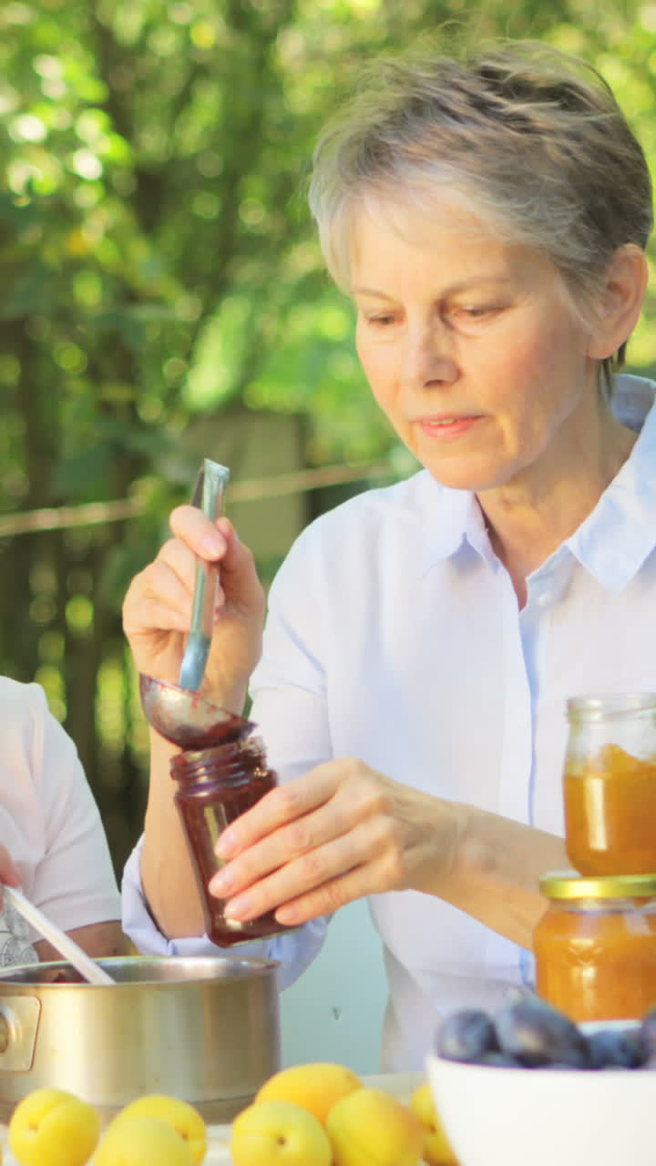 Senior women preparing jam in garden