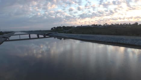 Wunderschöner-Sonnenaufgang-Und-Wolken,-Während-Eine-Drohne-In-Atemberaubender-4K-UHD-über-Das-Wasser-Gleitet