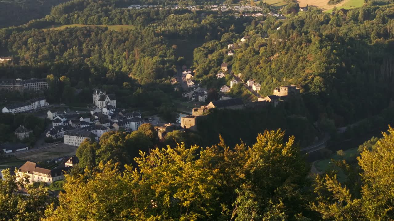 Cittadina pittoresca incastonata in una valle verde con un castello.