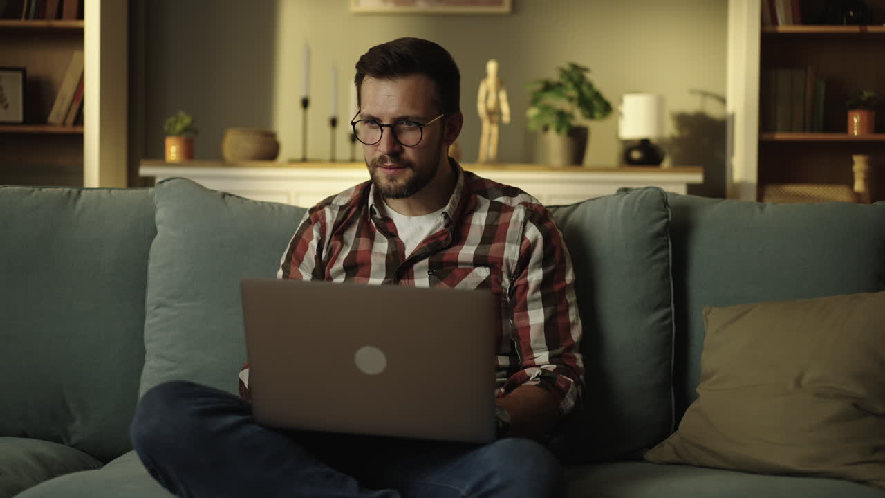 hombre trabajando en una computadora portátil en casa