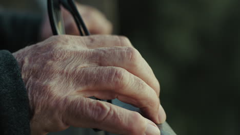 hand of an elderly man ticks impatiently on the railing waiting