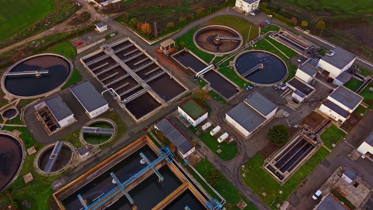 Modern wastewater treatment facility surrounded by lush green fields showcasing sustainable technology in action