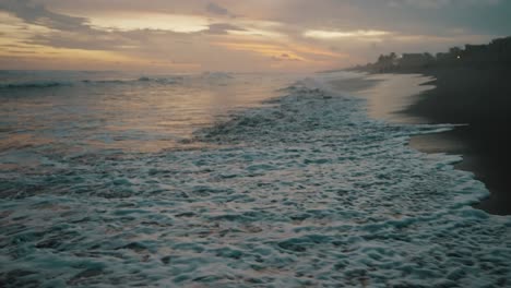 Tilt-up-Reveló-Olas-ásperas-Sobre-La-Costa-Arenosa-Al-Atardecer