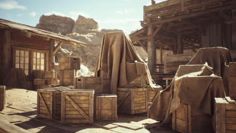 wooden crates and covered goods in a rustic western landscape during daylight