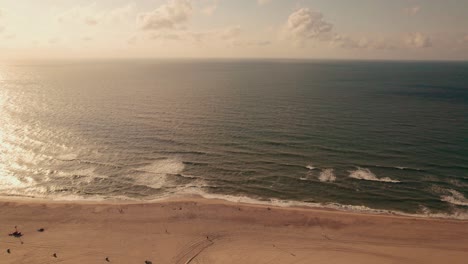 Vista-Aérea-Deslizante-De-La-Puesta-De-Sol-En-La-Playa-De-Kijkduin,-La-Haya