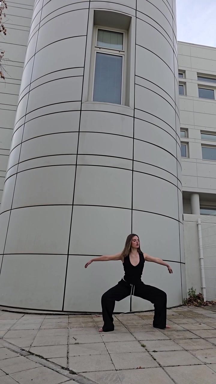 Vivi una vibrante performance di danza ambientata su uno sfondo architettonico moderno.