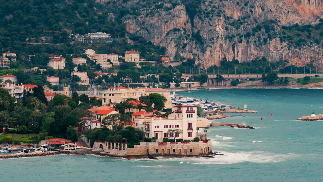 Beaulieu-sur-Mer, France - April 16, 2025: Distant view of the Villa Kerylos with the mountains on the background