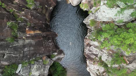 tourism style view of a woman floating in a secluded outback australian gorge